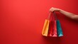 © 9DIGITECH - Shopping Bag Background: Female Hand Holding Colorful Bags on Yellow Background for Advertisement.