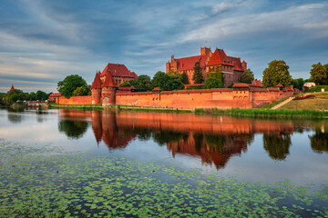 Sticker - Castle of theTeutonic Order in Malbork by the Nogat river at sunset.