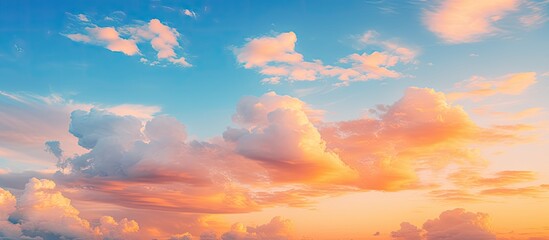 Wall Mural - Vibrant yellow and orange clouds contrasting with the colorful blue sky, creating a picturesque scene with copy space image.
