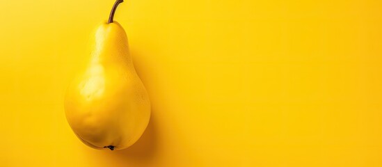 Leinwandbilder - Close up view of a single ripe pear on a vibrant yellow background, embodying an autumn fruit theme with a flat lay, top view and ample copy space image.