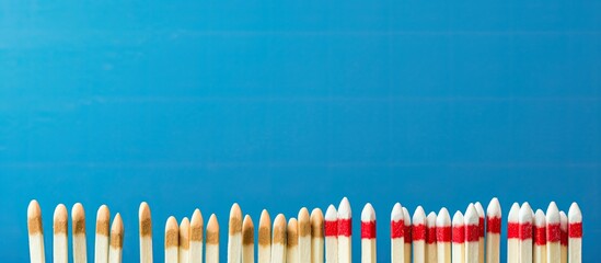 Poster - Close-up view of various new matchsticks on a blue background with copy space image.