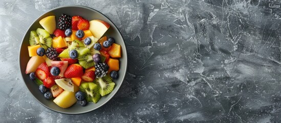 Leinwandbilder - Healthy fresh fruit salad in a bowl on a gray background. with copy space image. Place for adding text or design