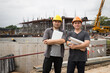 © skarie - Team of construction workers with blueprint project details in construction site. Success collaboration concept.