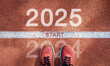 © Dee karen - New year 2025 concept, beginning of success. Text 2025 written on asphalt road and male runner preparing for the new year. Concept of challenge or career path and change.