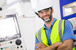 © winnievinzence - Portrait of confident male engineer foreman in safety helmet smile in arms crossed stand in front of factory production. man operating machine at industrial plant. men at work concept. copy space