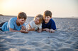 © Irina Schmidt - Three children playing with sand on sunset ocean beach. happy family, two school boys and one little preschool girl. Siblings having fun together. Bonding and family vacation in Andalucia, Spain