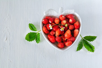 Wall Mural - Fresh ripe strawberry berries in a berry-shaped plate on a white wooden table