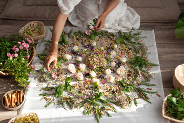 The girl collects a mandala from dried flowers and fresh flowers, symbolizing the world, the universe. Buddhism, Hinduism