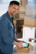 © auremar - young man unpacking cardboard boxes in new apartment