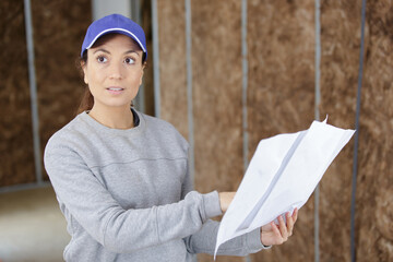 woman builder looking at architectural blueprint