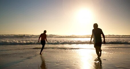 Canvas Print - Senior friends, beach and play in water with kick, splash or excited for funny game in summer sunshine. People, group or silhouette outdoor by ocean with running, joke or comic memory by sunset waves