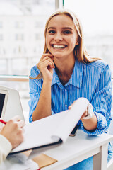 Wall Mural - Cheerful blonde woman worker happy about completing project successfully cooperating with colleague, young male and female partners working together in friendly atmosphere doing creative job in office