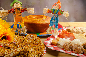 Wall Mural - Festa Junina, beautiful rustic table with dishes containing various types of sweets for Festa Junina in Brazil, selective focus.