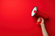 © Alexandra - Confident woman holding red megaphone against bold background, symbolizing communication and speaking out with copy space. Amplifying voice for attention-grabbing campaigns