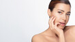 © Casther - Beautiful mature woman with natural glow, touching face, promoting healthy skincare, cosmetology concept