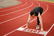 © Pixel-Shot - Sporty young man in sunglasses getting ready to run at stadium