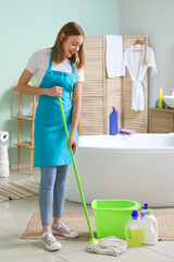 Poster - Young woman mopping floor in bathroom