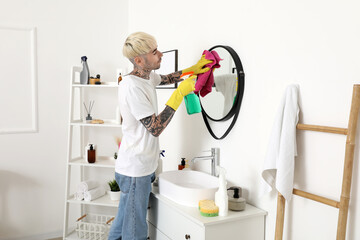 Sticker - Young tattooed man cleaning mirror in bathroom