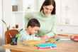 © Pixel-Shot - Cute little boy doing lessons with his mother at home