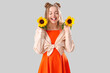 © Pixel-Shot - Young woman with beautiful sunflowers on light background