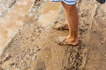 Womens feet in the mud dirt water