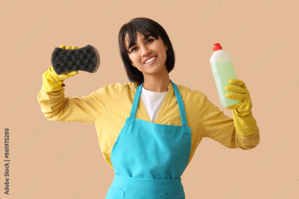 Young woman with sponge and detergent on beige background