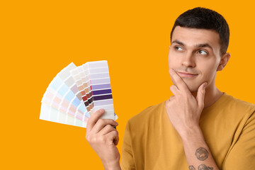 Canvas Print - Young man with paint palettes on yellow background