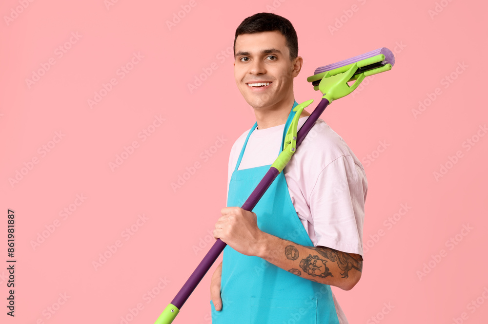 Male janitor with mop on pink background