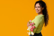 © Pixel-Shot - Beautiful young African-American woman with bouquet of tulips on yellow background. International Women's Day