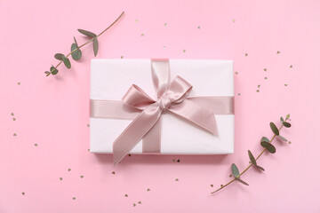 Wall Mural - Gift box and eucalyptus on pink background. International Women's Day