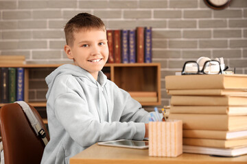 Sticker - Teenage boy with books studying at table in library