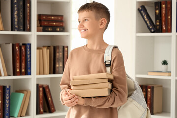 Canvas Print - Teenage boy with backpack and books in library