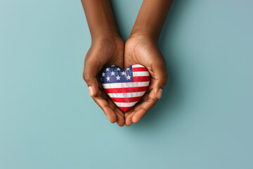 Wall Mural - Hands holding heart made of national American flag on light blue background. Top view, copy space