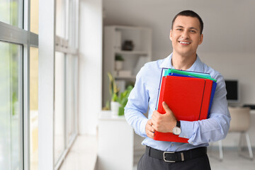 Wall Mural - Male accountant with folders near window in office