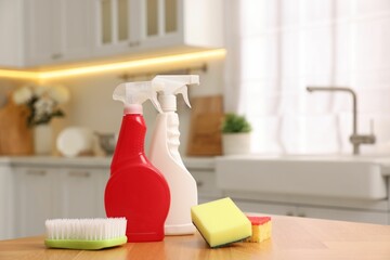 Canvas Print - Cleaning service. Detergents, sponges and brush on table in kitchen. Space for text