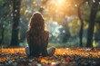 © LifeMedia - A woman with long hair sits in a sunlit forest amidst fallen autumn leaves, creating a serene and peaceful atmosphere that highlights nature's beauty and tranquility.