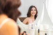 © Art_Photo - Smiling of beautiful asian woman fresh healthy white skin, clean, looking at mirror.asian girl touching on face applying cream, skincare, cosmetics, cosmetology, beauty, fashion at home.spa, wellness
