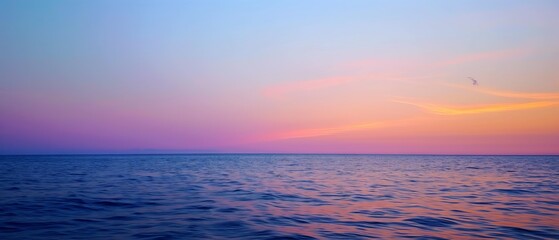 Wall Mural - Sunset at sea: Orange-pink hues of the sunset, fading into the deep blue of the water and sky