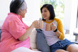 © Wavebreak Media - Mother and daughter enjoying coffee, sitting on couch, smiling and talking
