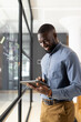 © Wavebreak Media - Using tablet, male business professional writing on glass wall in office