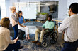 © Wavebreak Media - Group of business people in meeting, man in wheelchair using laptop for presentation