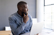 © Wavebreak Media - Holding laptop, business man looking out window, contemplating ideas in office