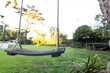 © Wavebreak Media - Empty wooden swing hanging in backyard garden on sunny day, copy space