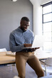 © Wavebreak Media - Businessman in office using laptop and smiling while working on project