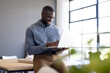 © Wavebreak Media - Using laptop, business man smiling and working in modern office setting