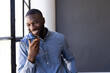 © Wavebreak Media - Businessman in office smiling while recording voice message on smartphone