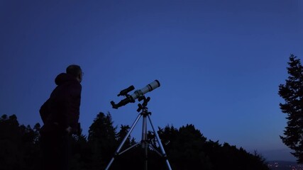 Wall Mural - amateur astronomer looking at the evening skies, observing planets, stars, moon and other celestial 
