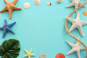 Wall Mural - nautical concept with starfish and seashells over blue background