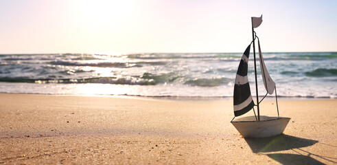 Wall Mural - Small vintage boat on beach at summer sunset