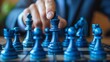 © LittleDreamStocks - Hand moving a blue chess king piece on a board.
